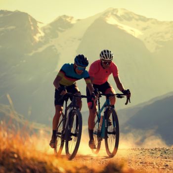 Två män som cyklar landsvägscykel uppför en backe.